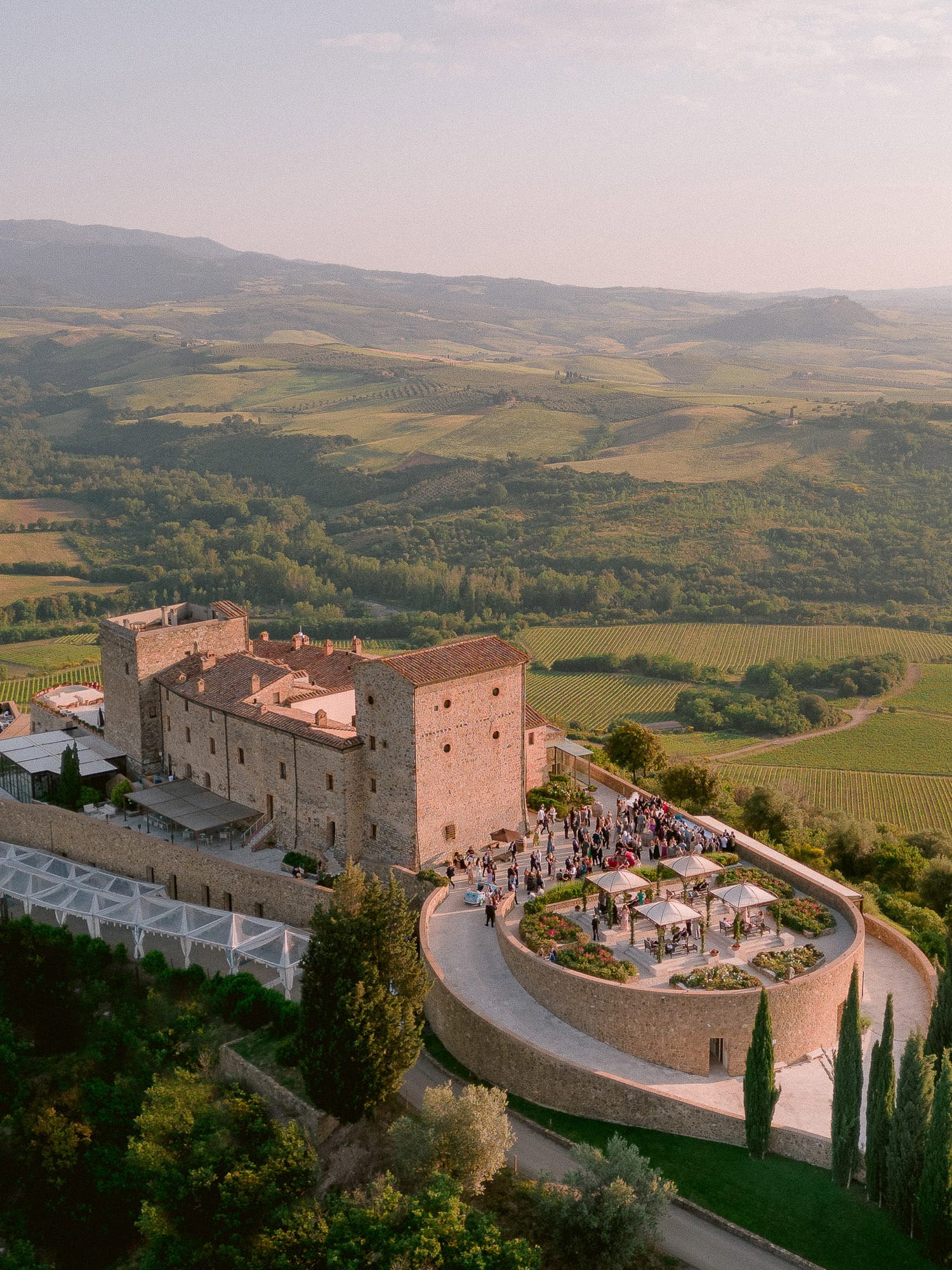 aerial view of castello di Velona during the cocktail hour with the view of the tuscan countryside as the backdrop